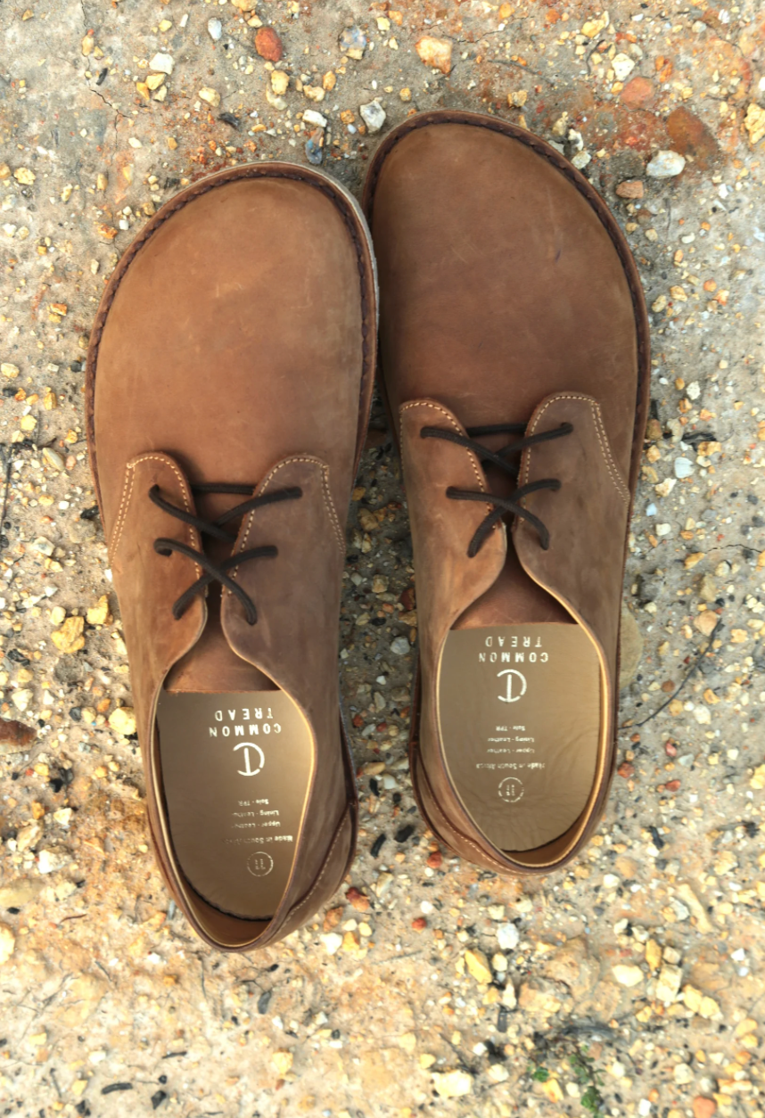 Top view of Common Tread Traversa men’s barefoot leather shoes on natural ground