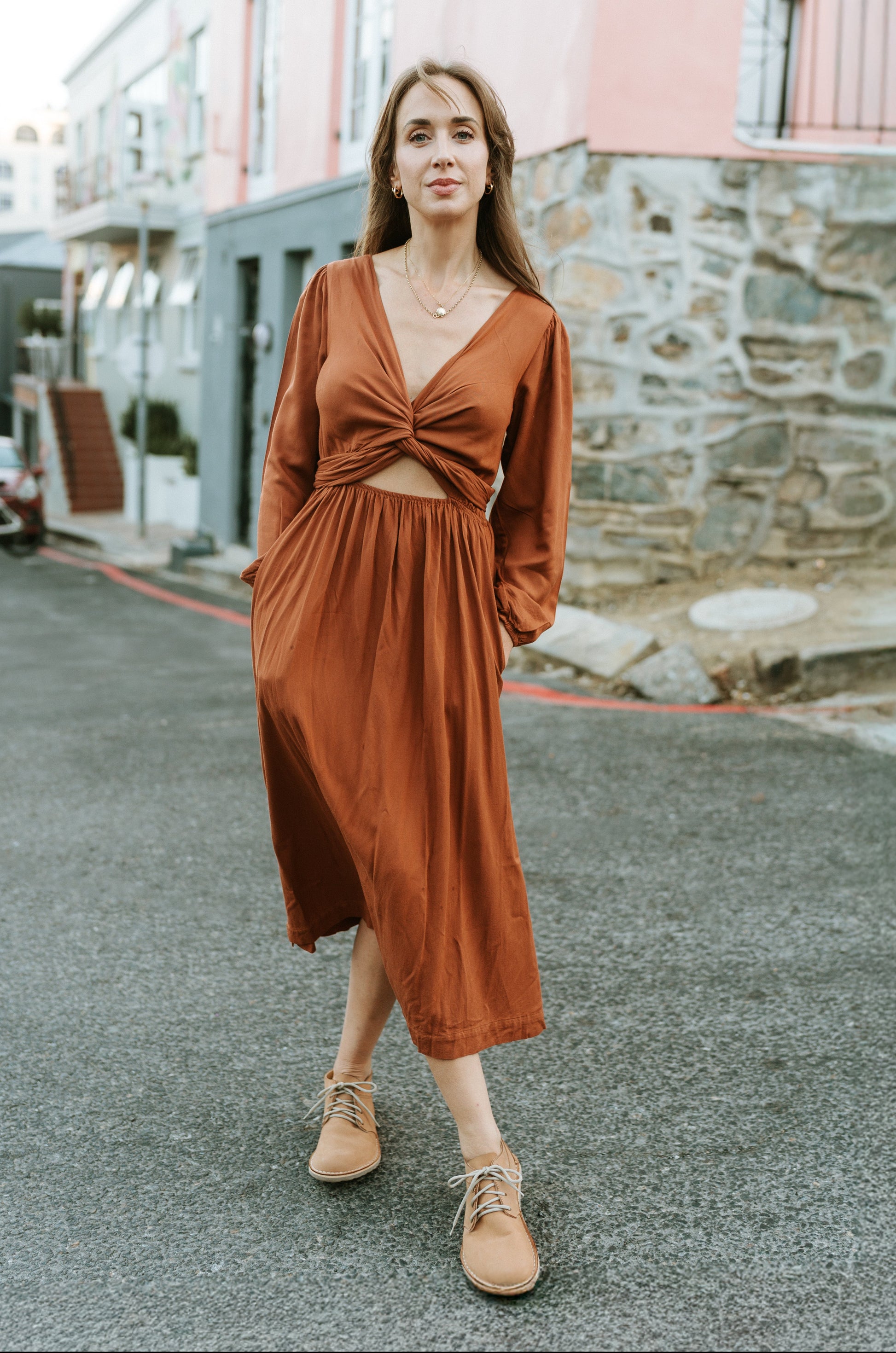 Woman wearing Common Tread Tundra women’s barefoot leather shoes with a rust dress