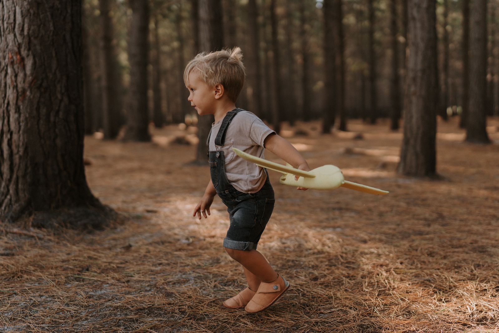 Child running through forest wearing Common Tread Evergreen barefoot shoes